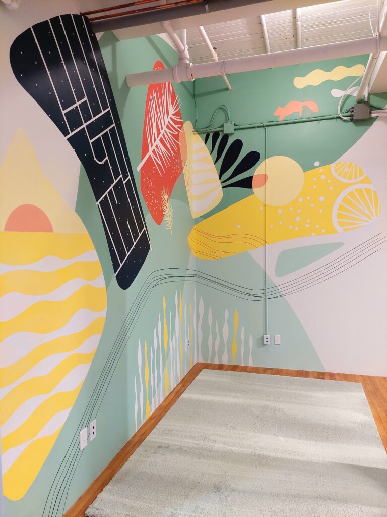 A view of the mural painted on the walls in our office. It's composed of abstract shapes in a variety of colors.