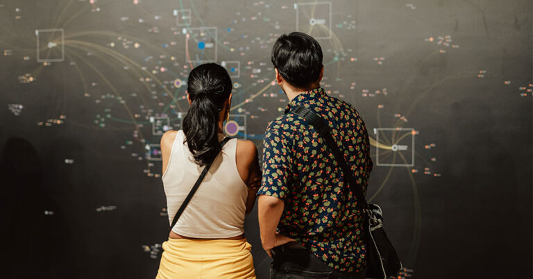 two people at the exhibition looking at a map of data