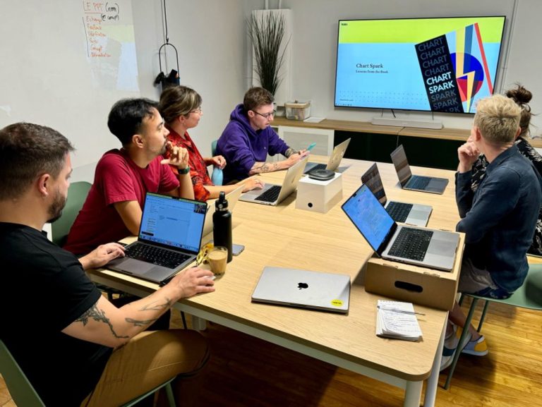 Photo of the Voilà: team looking at a presentation of the book and what we can learn about it.