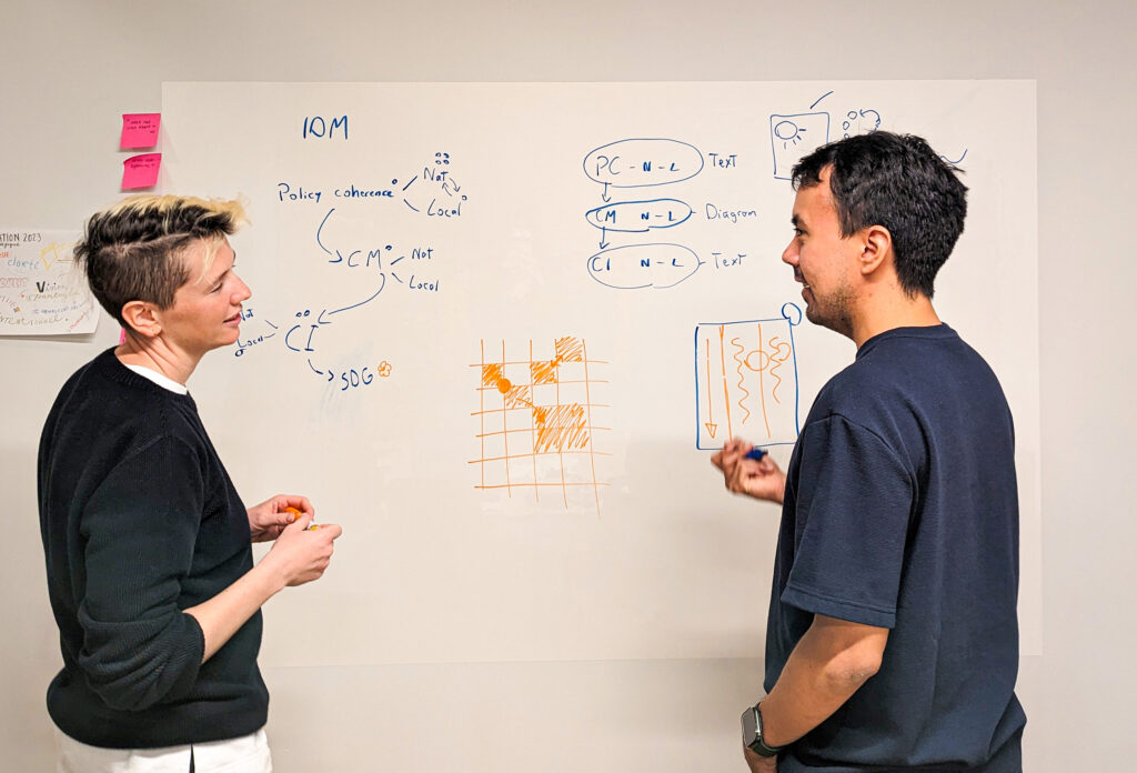 Celia Albano and Julian Hernandez, graphic designer and information designer respectively, are brainstorming together, drawing diagrams with felt-tip pens on the whiteboard in our office. We see them facing each other, smiling and chatting with felt-tip pens in hand.