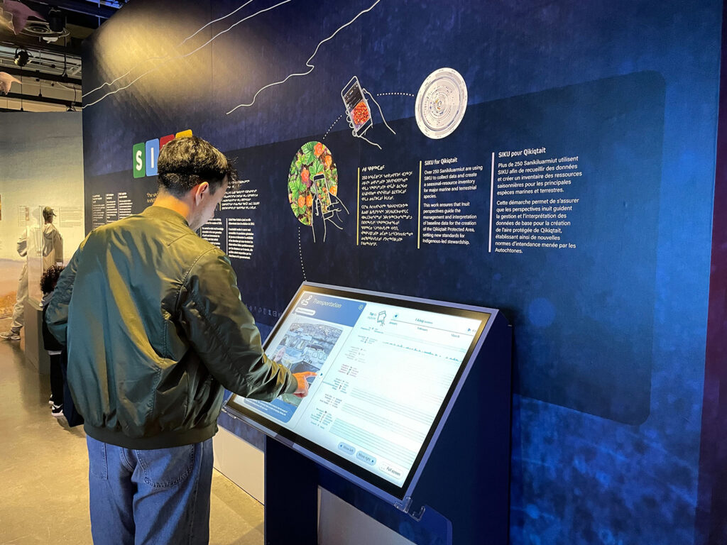 Un visiteur utilisant la Roue des ressources arctiques sur un écran tactile au Musée canadien de la nature.